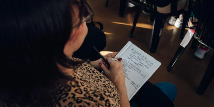 Personas en un aula de capacitación con profesores y materiales de estudio