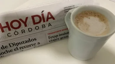 Persona leyendo el diario en papel con una taza de café