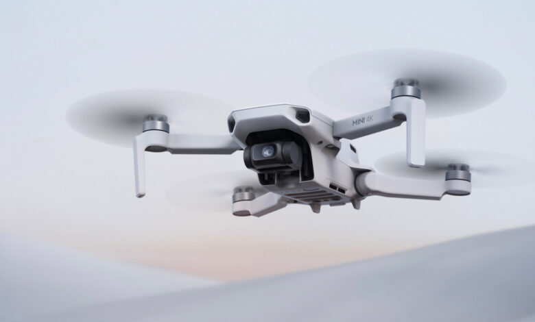 DJI Mini 4K en vuelo con un paisaje urbano al fondo