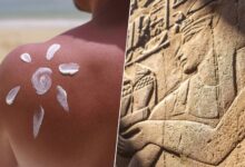 Persona aplicando protector solar en la playa