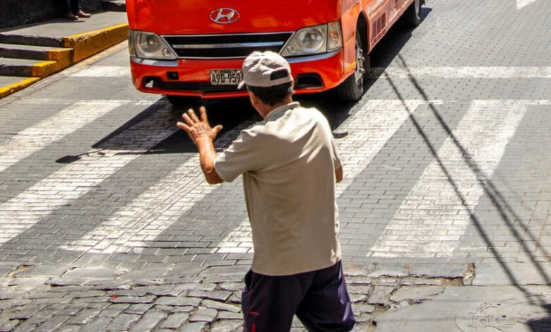 Persona saludando a un conductor al cruzar la calle