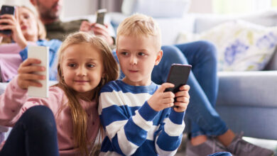 Niños leyendo en un teléfono móvil