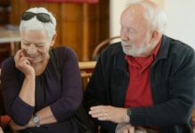Mujer mayor sonriente, rodeada de familiares, simbolizando la longevidad y la felicidad