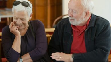 Mujer mayor sonriente, rodeada de familiares, simbolizando la longevidad y la felicidad
