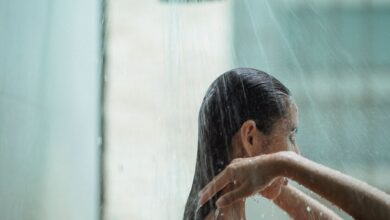 Persona relajándose bajo el chorro de la ducha