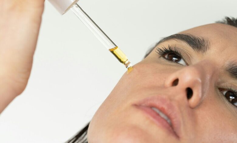 Imagen de una botella de sérum de vitamina C sobre una base de protector solar, simbolizando la protección combinada.