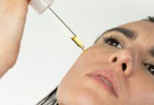 Imagen de una persona aplicando un protector solar y un sérum de vitamina C en su piel