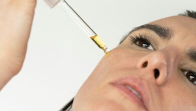 Imagen de una persona aplicando un protector solar y un sérum de vitamina C en su piel