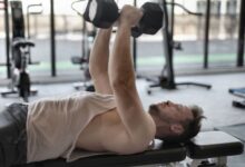 Persona mayor realizando ejercicios de fuerza en un gimnasio