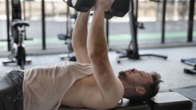 Persona mayor realizando ejercicios de fuerza en un gimnasio