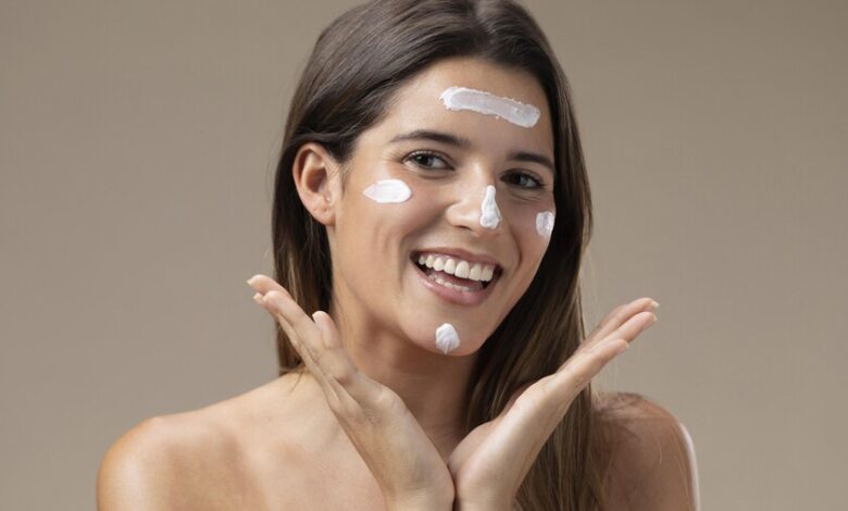 Persona aplicando crema solar en la cara
