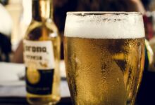 Persona bebiendo cerveza en la playa