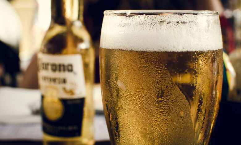 Persona bebiendo cerveza en la playa