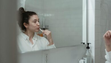 Persona cepillándose los dientes frente al espejo