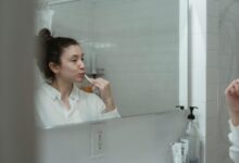 Persona cepillando sus dientes con un cepillo de dientes eléctrico
