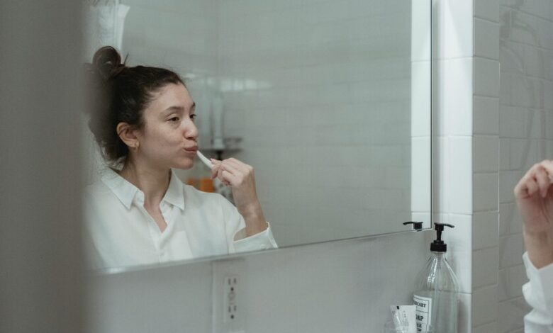 Persona cepillando sus dientes con un cepillo de dientes eléctrico