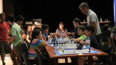 Niños y adultos jugando ajedrez en un parque