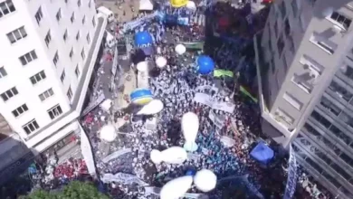 Imagen de una marcha de protesta en la calle, con personas llevando carteles y banderas.