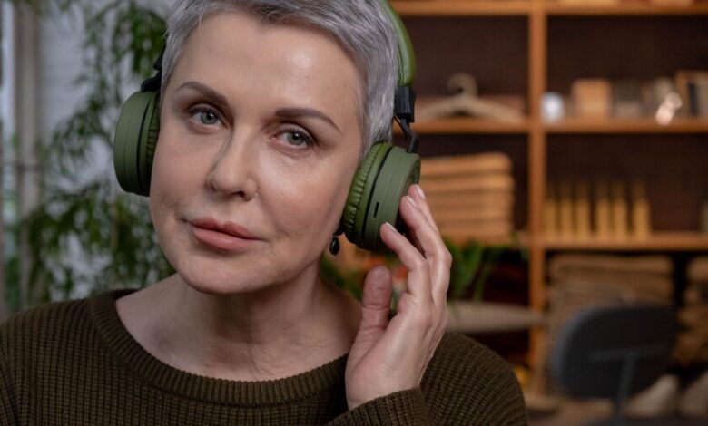 Persona usando auriculares inalámbricos, con un fondo que representa ondas de radio