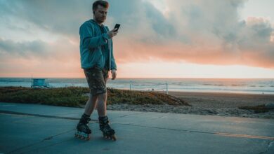 Persona caminando por la calle mientras mira su teléfono móvil