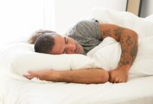 Persona durmiendo con la pantalla de televisión encendida y auriculares