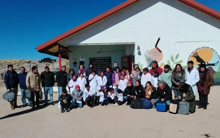 Imagen de una escuela de alta montaña en Córdoba, Argentina, con estudiantes y docentes en el patio.