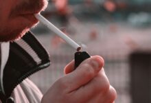 Persona mayor fumando en una terraza, símbolo de la soledad vinculada al tabaco