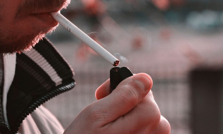 Persona mayor fumando en una terraza, símbolo de la soledad vinculada al tabaco