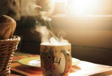 Taza de café humeante sobre una mesa, ilustrando la peligrosidad de las bebidas muy calientes