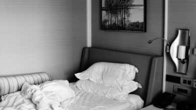 Cama sin hacer con sábanas arrugadas sobre un colchón blanco