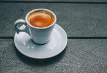 Taza de café humeante sobre una mesa, símbolo del estudio sobre microbioma intestinal