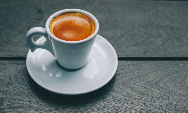 Taza de café humeante sobre una mesa, símbolo del estudio sobre microbioma intestinal