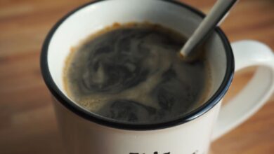 Taza de café humeante sobre una mesa de madera