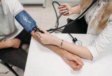 Mano de médico tomando la presión arterial a un paciente de edad avanzada