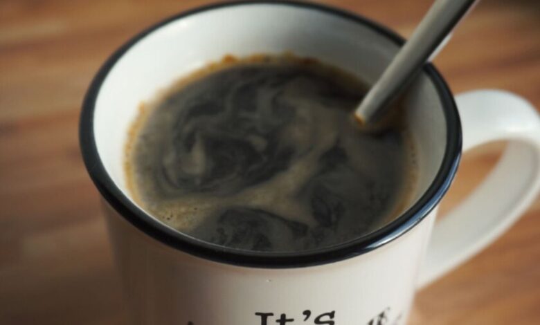 Taza de café humeante sobre mesa al amanecer