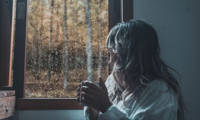Persona disfrutando de la lluvia mientras escucha el sonido del agua