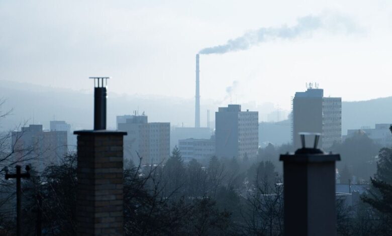 Imagen que muestra una ciudad con smog y partículas contaminantes en el aire