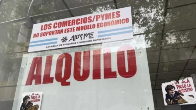 Faja roja con mensaje 'Los comercios / Pymes no soportan el modelo económico' colgada en la vitrina de un comercio del centro de Córdoba